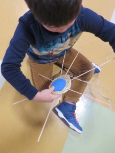 Enfant tressant une armature en rotin