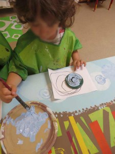 Enfant qui enduit son tampon de peinture