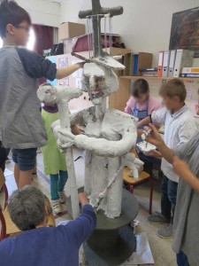 Les enfants peignent leurs sculpture en blanc