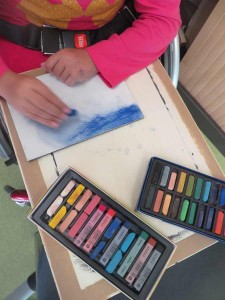 Enfant qui dessine avec des pastels