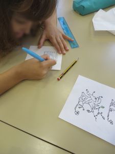 Fillette qui dessine sa lettre décorée