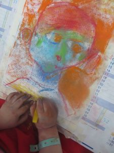 Un enfant dessine son portrait en couleur