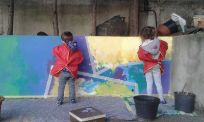 Les enfants s'appliquent à peindre une fresque