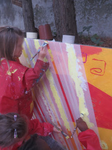 Fillette qui peint sur le mur de son école