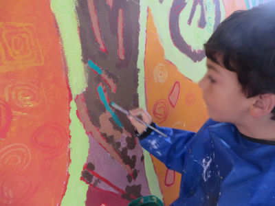 Un enfant réalise les derniers détails de la fresque