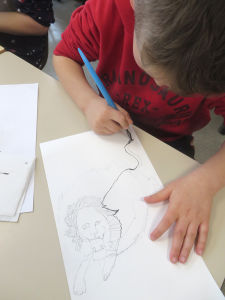 Enfant qui dessine à l'école