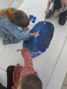 Les enfants peignent le fond coloré