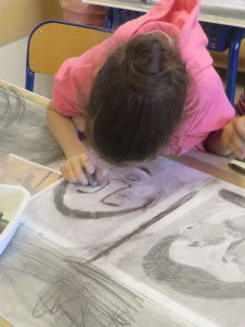 Fillette qui dessine son autoportrait à l'école