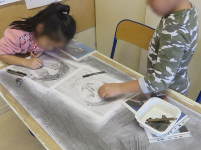 Les enfants réalisent un grand dessin collectif