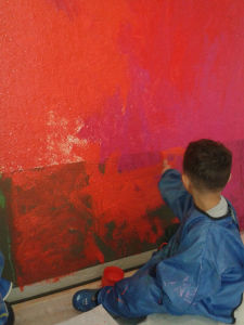Enfant de PS/MS en tran de peindre le mur