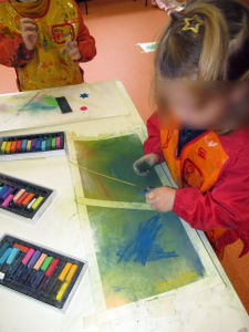 Fillette qui joue avec les pastels