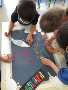 Les enfants collaborent pour peindre une oeuvre collective