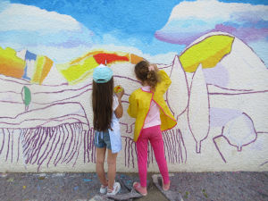 Fillettes qui peignent une fresque dans leur école