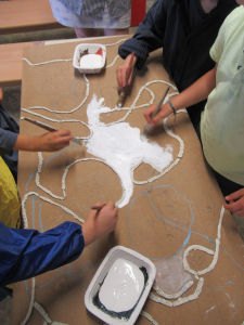 Les enfants peignent le tableau en classe