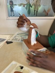 Les enfants peignent leur sculpture encore fraiche