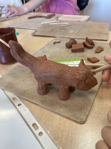 Modelage d'un animal en argile rouge