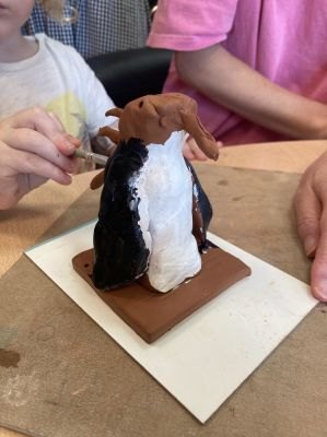 Charles peint sa statuette de pingouin