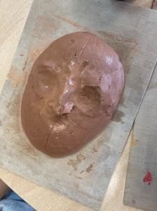 Déformer une plaque d'argile et placer les yeux et le nez