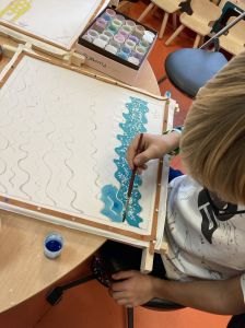 Marcel, 7 ans, peint un foulard pour sa maman