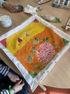 Le carré de soie est enlevé du cadre en bois