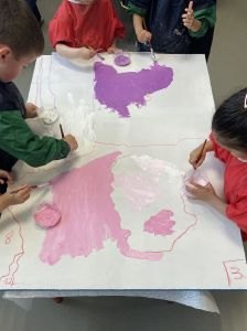Les enfants peignent des tableaux pour décorer la cour