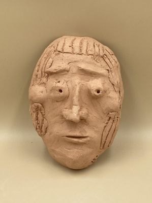 Visage en argile modelé par un enfant